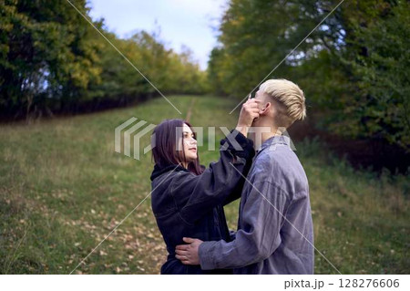 two 15-year-old teenagers in love play, hug, spend time together in an autumn park two 15-year-old teenagers in love play, hug, spend time together in an autumn park 128276606