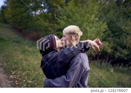 two 15-year-old teenagers in love play, hug, spend time together in an autumn park two 15-year-old teenagers in love play, hug, spend time together in an autumn park 128276607