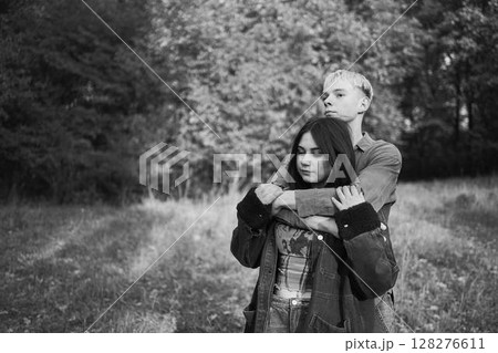 two 15-year-old teenagers in love play, hug, spend time together in an autumn park two 15-year-old teenagers in love play, hug, spend time together in an autumn park 128276611