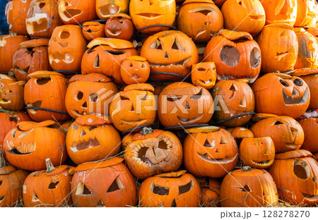 Stack of carved Halloween pumpkins with funny and scary faces 128278270