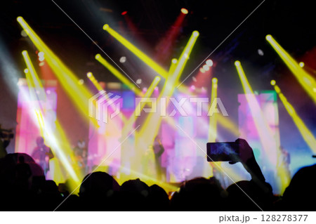 Blurred background, Bokeh lighting in outdoor concert with cheering audience. Viewers taking photo with phones. 128278377