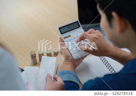 Expense Management and Budgeting. Young couple calculating finances with receipts and coins. 128278518