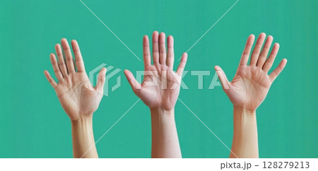 Hands Raised up in Front Green Backdrop Displaying openness and participation. 128279213