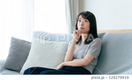 ソファに座って考えごとをする女性 128279919