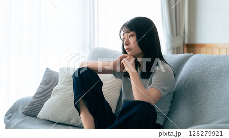 ソファに座って考えごとをする女性 128279921