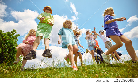 Jump squad. Cheerful kids enjoying themselves outside on a sunny day 128280099