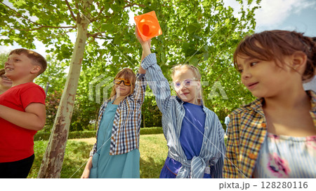 Kids enjoying outdoor activities in a sunlit park in summer Kids enjoying outdoor activities in a sunlit park in summer 128280116