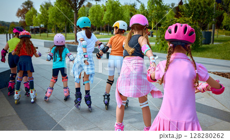 Kids skating in park using vibrant safety gear 128280262