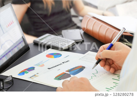 Businessman with pen analyzing financial documents in the office Businessman with pen analyzing financial documents in the office 128280278