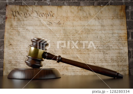 United States Constitution On Wall with Gavel Resting on Table in Front. United States Constitution On Wall with Gavel Resting on Table in Front. 128280334