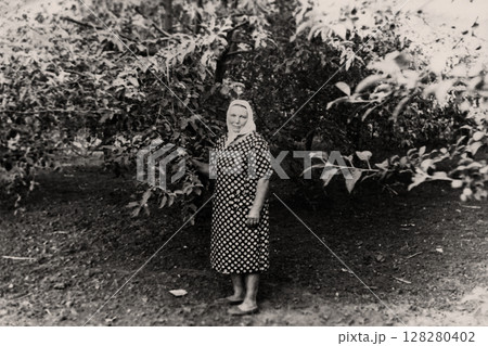 Vintage portrait of a woman in a summer garden. Retro photo 1960. Apolonovka, Kharkov, Ukraine. 128280402