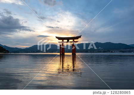 Famous red torii gate of Itsukushima shrine at sunset in Miyajima, Japan 128280865