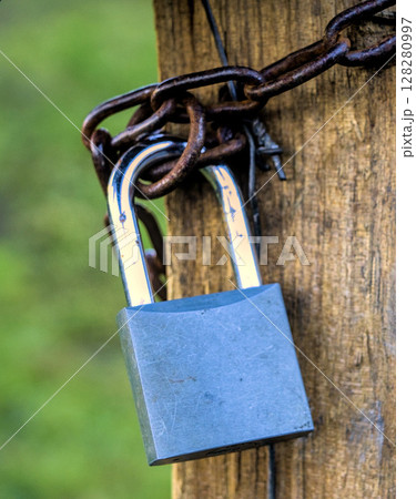 Padlock secured with a chain 128280997