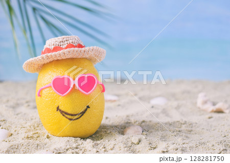 Creative minimal summer idea. Lemon citrus hipster in pink sunglasses and bamboo hat on sand. Tropical beach concept. Creative art. Fun party Mood. Copy space Creative minimal summer idea. Lemon citrus hipster in pink sunglasses and bamboo hat on sand. Tropical beach concept. Creative art. Fun party Mood. Copy space 128281750