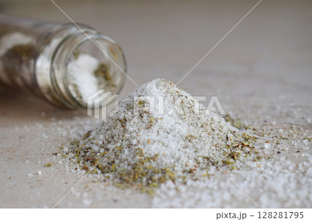 Ayurvedic herbal salt in glass jar. Sea salt with aromatic herb - rosemary, oregano, sage, marjoram, basil, thyme, mint, bay leaf. Copy space 128281795