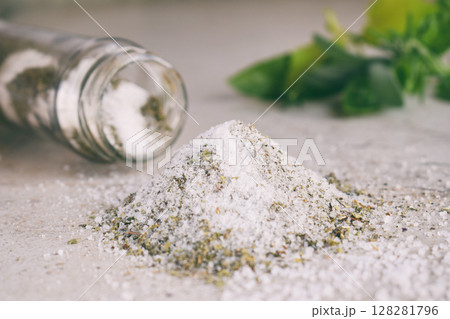 Ayurvedic herbal salt in glass jar. Sea salt with aromatic herb - rosemary, oregano, sage, marjoram, basil, thyme, mint, bay leaf. Copy space 128281796