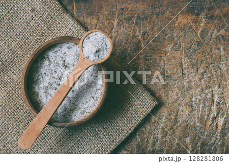 Ayurvedic herbal salt in wooden spoon. Sea salt with aromatic herb - rosemary, oregano, sage, marjoram, basil, thyme, mint, bay leaf. Copy space Ayurvedic herbal salt in wooden spoon. Sea salt with aromatic herb - rosemary, oregano, sage, marjoram, basil, thyme, mint, bay leaf. Copy space 128281806
