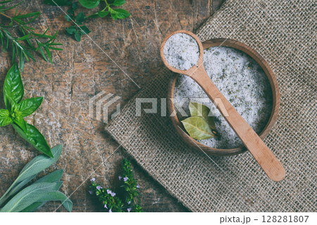 Ayurvedic herbal salt in wooden spoon. Sea salt with aromatic herb - rosemary, oregano, sage, marjoram, basil, thyme, mint, bay leaf. Copy space Ayurvedic herbal salt in wooden spoon. Sea salt with aromatic herb - rosemary, oregano, sage, marjoram, basil, thyme, mint, bay leaf. Copy space 128281807