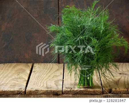 bunch of dill on wooden background 128281847