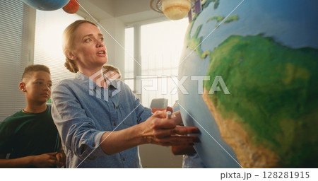 STEM Class: Female Teacher Explaining Renewable Energy to Team of Smart Kids Using Earth Model STEM Class: Female Teacher Explaining Renewable Energy to Team of Smart Kids Using Earth Model 128281915