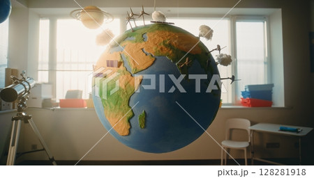 Globe with Miniature 3D Models of Wind Turbines and Solar Panels Hanging in Modern Classroom Globe with Miniature 3D Models of Wind Turbines and Solar Panels Hanging in Modern Classroom 128281918