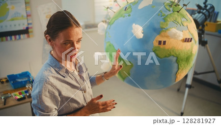 Female School Teacher Educating Science and Renewable Energy Sources Using Model of Planet Earth Female School Teacher Educating Science and Renewable Energy Sources Using Model of Planet Earth 128281927