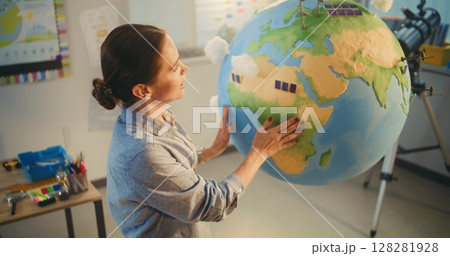 Female School Teacher Educating Science and Renewable Energy Sources Using Model of Planet Earth Female School Teacher Educating Science and Renewable Energy Sources Using Model of Planet Earth 128281928