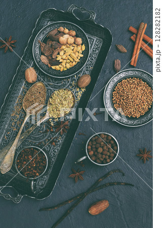 Spices for baking gingerbread, muffins or mulled wine - vanilla, cinnamon, coriander, cloves cardamom fennel nutmeg on grey background 128282182