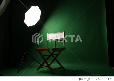 Chair of Film Director. Directors chair in green screen studio setup with softbox lighting. Ideal for filmmaking video production photo interviews and creative content with green chroma key background 128282847
