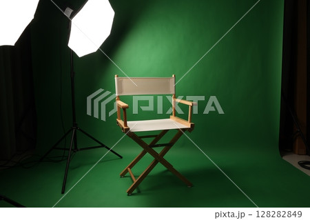 Chair of Film Director. Directors chair in green screen studio setup with softbox lighting. Ideal for filmmaking video production photo interviews and creative content with green chroma key background Chair of Film Director. Directors chair in green screen studio setup with softbox lighting. Ideal for filmmaking video production photo interviews and creative content with green chroma key background 128282849