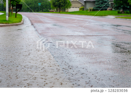 Backed up standing water on a residential street after a rain storm downpour.  128283036
