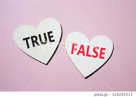 True or False symbol. Concept word True or False on wooden hearts. Beautiful pink background. Business and True or False concept. Copy space True or False symbol. Concept word True or False on wooden hearts. Beautiful pink background. Business and True or False concept. Copy space 128283313