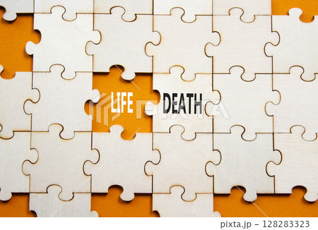 Life or Death symbol. Concept word Life or Death on wooden puzzle. Beautiful orange background. Business and Life or Death concept. Copy space 128283323