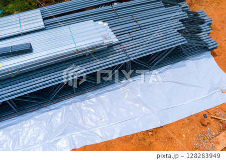 Steel construction materials are organized on ground at building site during works day 128283949