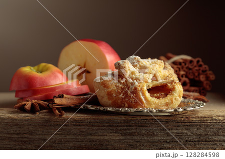 Viennese strudel with apple and cinnamon on old wooden table. Viennese strudel with apple and cinnamon on old wooden table. 128284598
