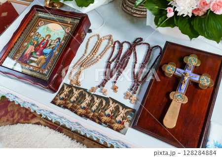 Orthodox Christian Prayer Set: Icon, Rosary Beads, and Cross on White Table, Religious Devotion Scene, Dark Wood Texture Orthodox Christian Prayer Set: Icon, Rosary Beads, and Cross on White Table, Religious Devotion Scene, Dark Wood Texture 128284884