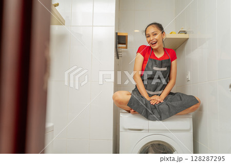 Playful Woman Enjoying Bright Laundry Room: Captivating Home Lifestyle 128287295