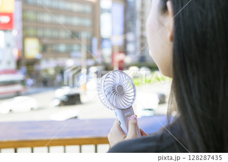 ハンディファンを使う女性 128287435