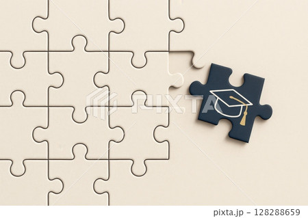 Missing puzzle piece with graduation cap completes a nearly finished puzzle 128288659