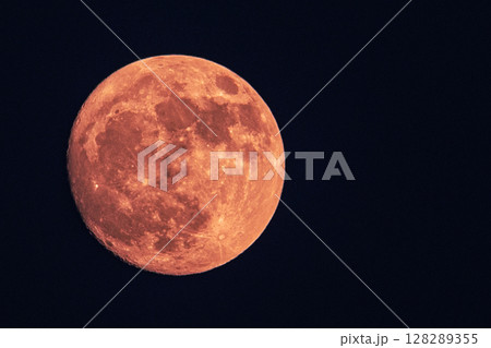 Red full moon over dark sky at night 128289355