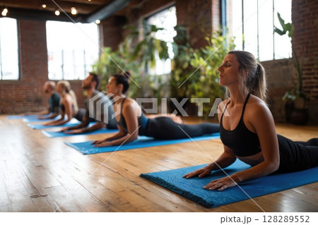 group of people practicing yoga in an indoor gym 128289552