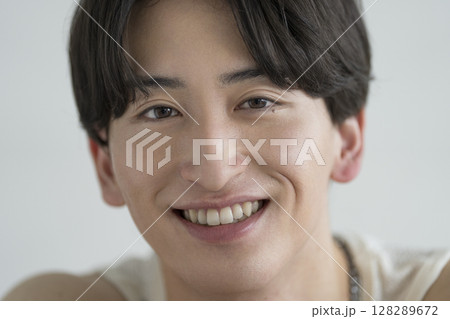 カメラ目線で笑顔の20代の男性　メンズビューティーイメージ　ポートレート 128289672