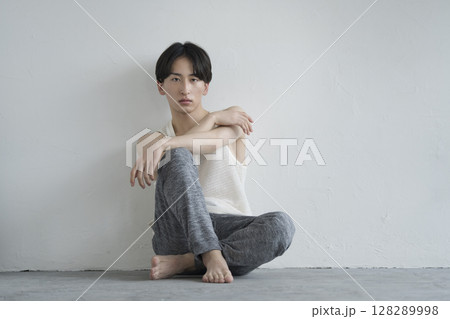 カメラ目線で座る20代の男性 メンズビューティーイメージ ポートレート カメラ目線で座る20代の男性 メンズビューティーイメージ ポートレート 128289998