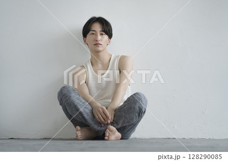 カメラ目線で座る20代の男性　メンズビューティーイメージ　ポートレート 128290085