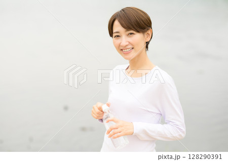 公園でペットボトルを手に持つ女性 公園でペットボトルを手に持つ女性 128290391