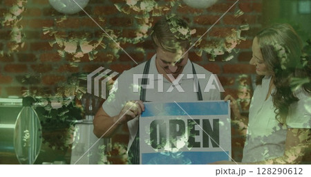 Small business owners placing open sign on cafe door, ready to welcome customers Small business owners placing open sign on cafe door, ready to welcome customers 128290612