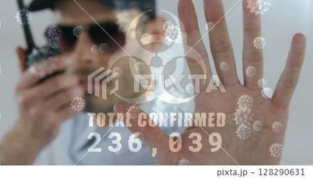 Image of a hazard sign with total confirmed number rising with cells floating over caucasian man Image of a hazard sign with total confirmed number rising with cells floating over caucasian man 128290631