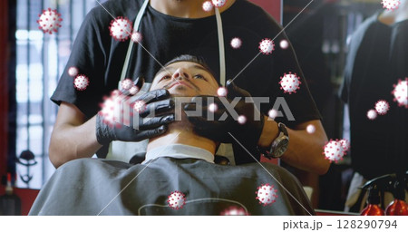 Image of cells spreading over man getting facial at a barbershop by barber wearing surgical gloves 128290794