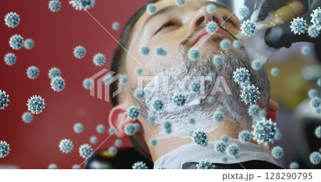 Barber shaving man's beard while virus particles conceptually surround him 128290795