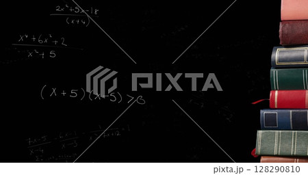 Image of mathematical formulae moving over stack of books on black chalkboard in the background 128290810